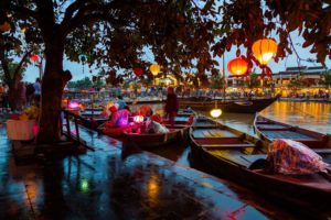 Lantern-lit wooden boats on the Hoi An river at twilight