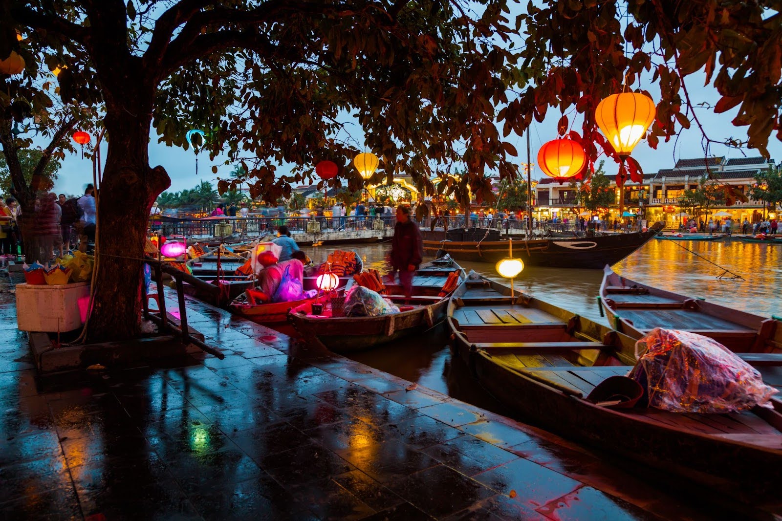 Lantern-lit wooden boats on the Hoi An river at twilight