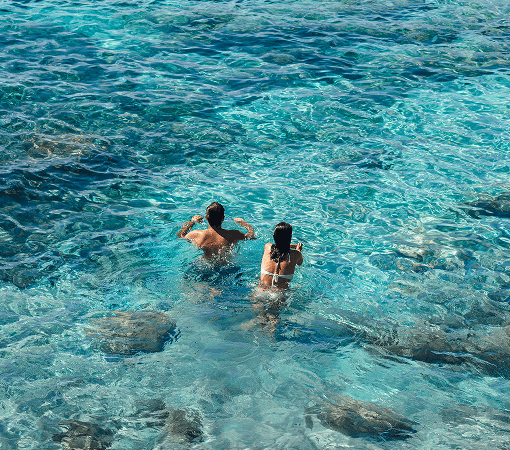 happy couple swimming in the transparent water