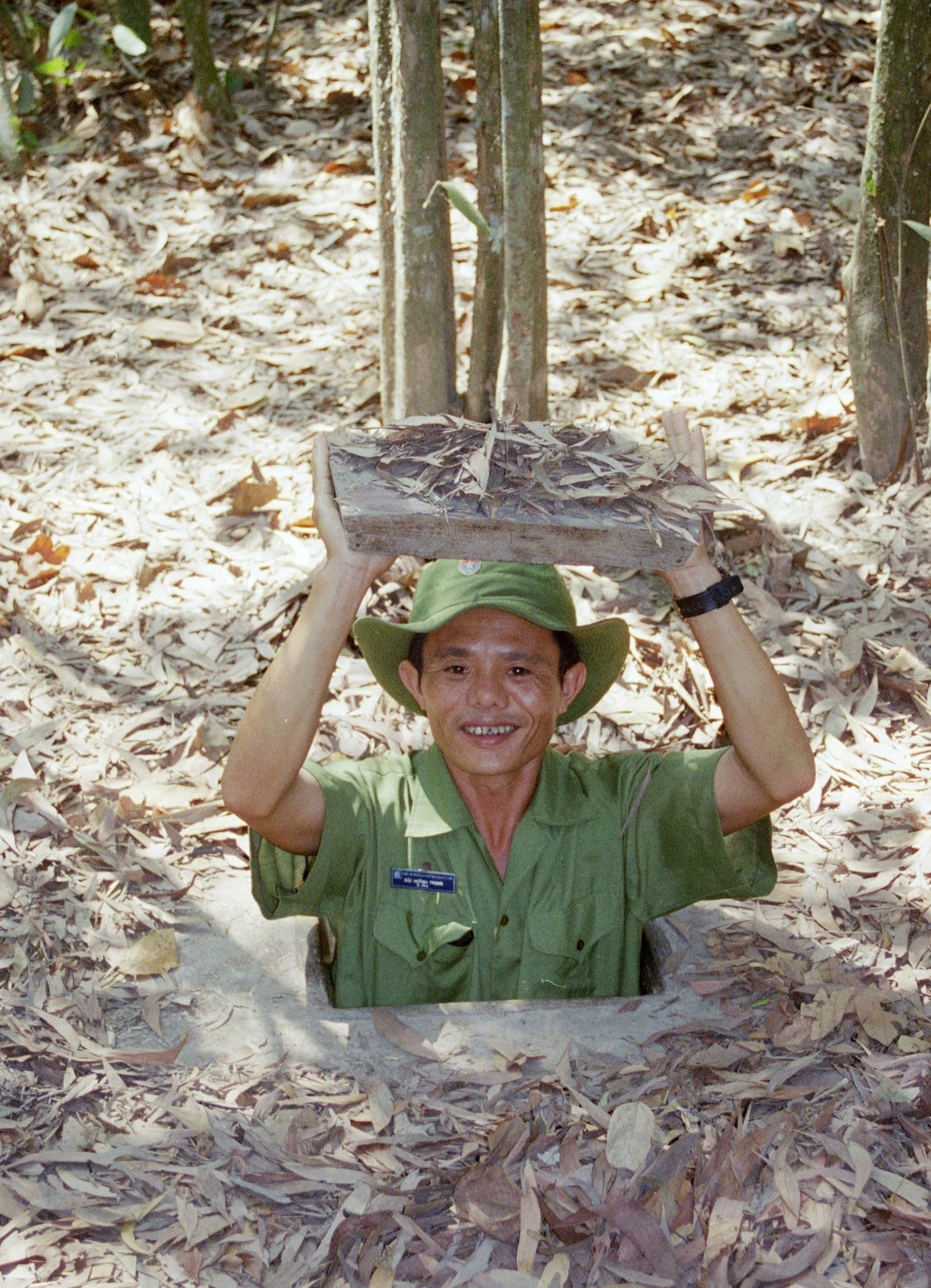 vietnam cu chi tour guide coming out from the tunnel